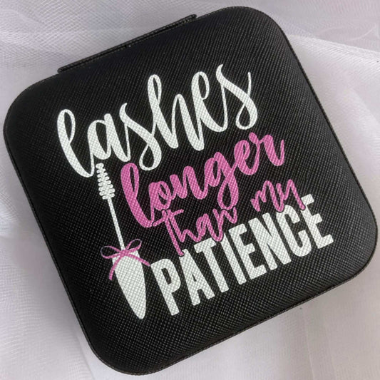 Cute travel jewelry organizer with a funny quote. Black box with white and pink letters. White mascara brush with a pink bow. Saying reads: Lashes longer than my patience.